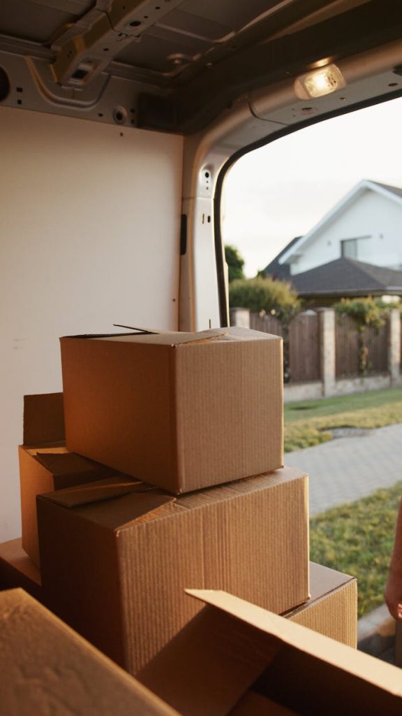 View inside a delivery van with stacked cardboard boxes ready for moving.